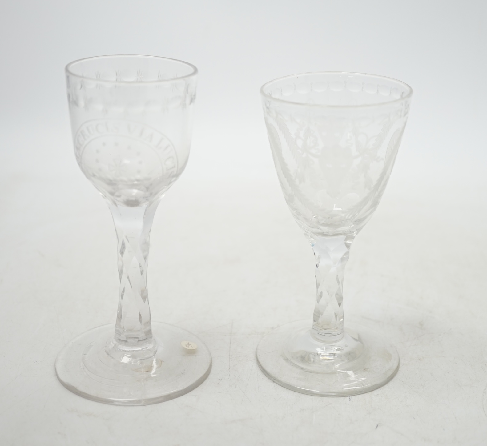 Two 18th century wine glasses with faceted stems, both with engraved bowls, one neo-classical and one reading ‘Via Crucis Via Lucis’, tallest 13.5cm. Condition - good